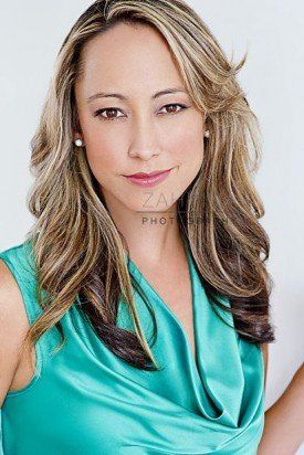 A woman in a green top is smiling for the camera