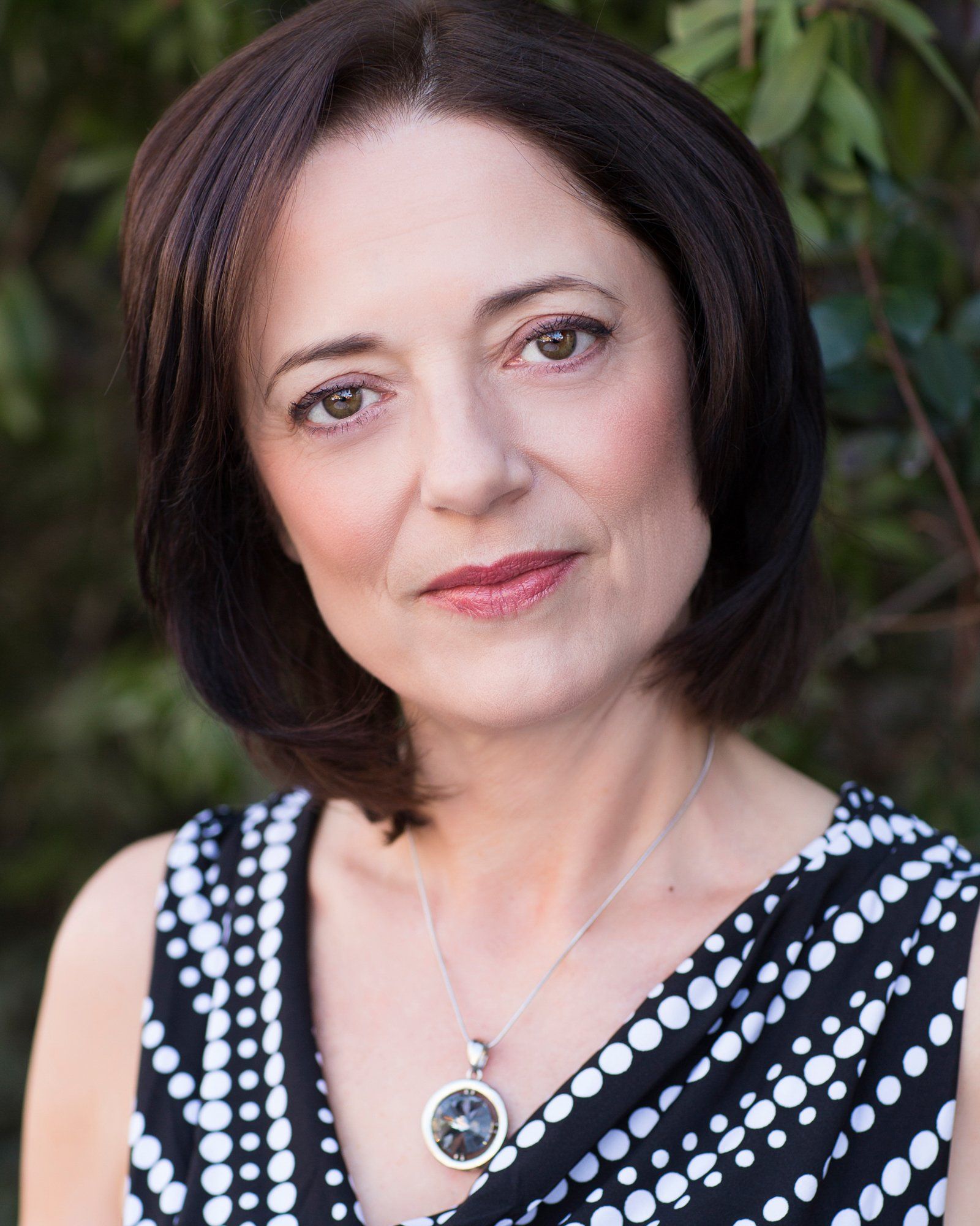 A woman wearing a black and white polka dot dress and a necklace