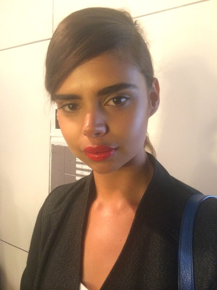 A woman wearing red lipstick and a black jacket