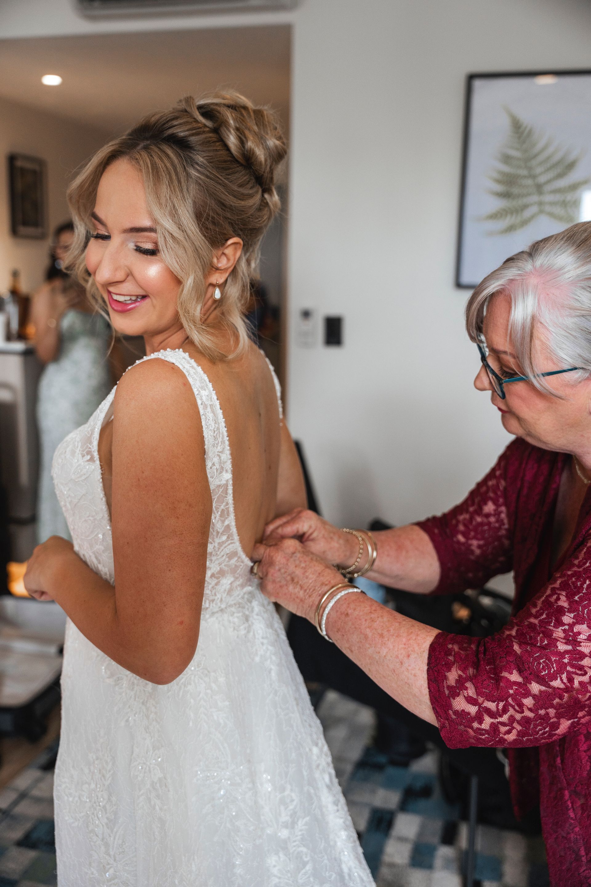 bride and mother getting ready fixing dress and hair and makeup