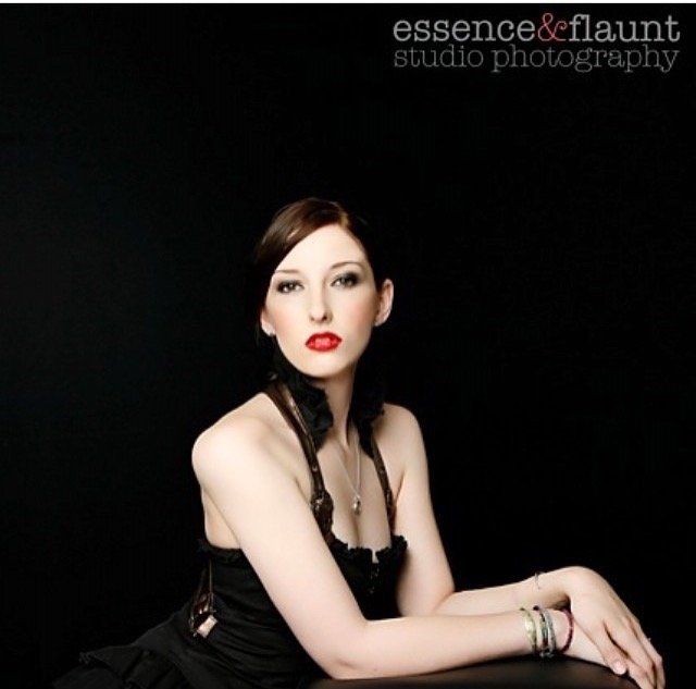 A woman in a black dress is photographed by essence & flaunt studio photography