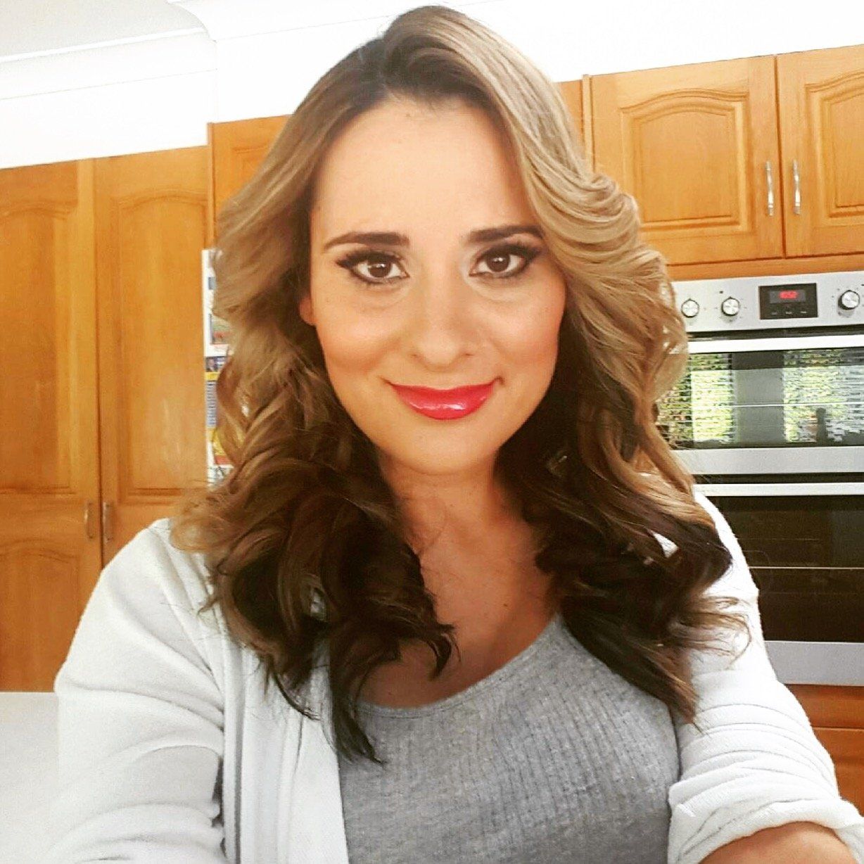 A woman taking a selfie in front of an oven