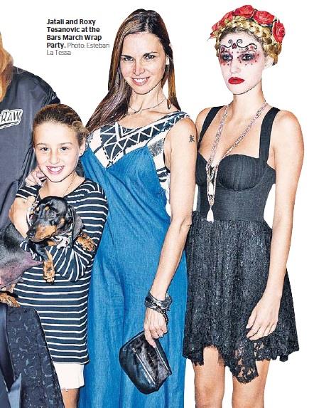 A woman in a blue dress is standing next to two other women