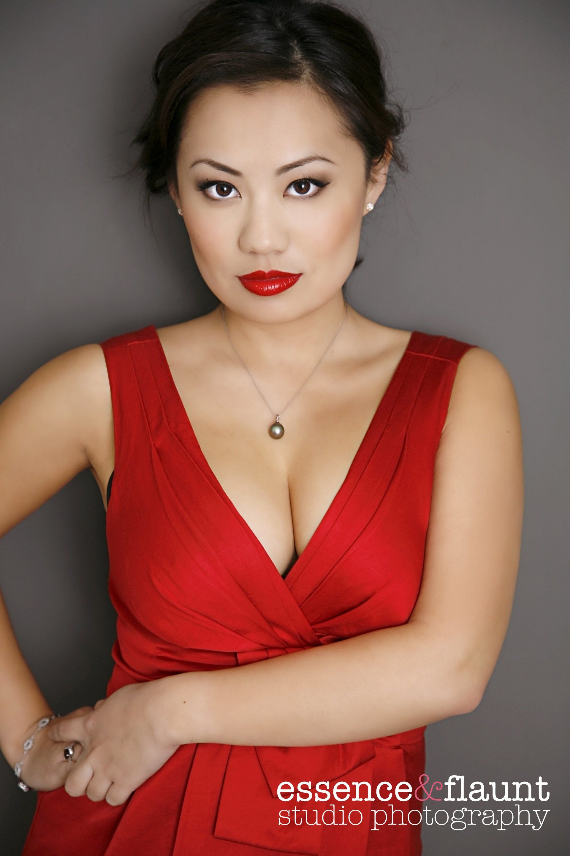 A woman in a red dress is standing with her hands on her hips