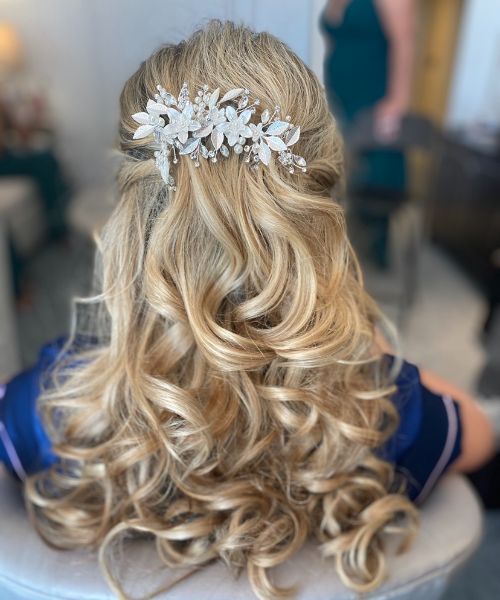 A woman with long blonde hair is wearing a comb in her hair.