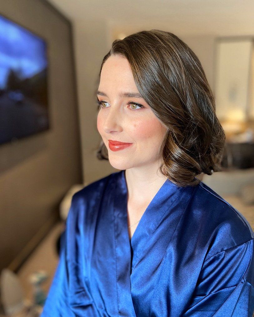 A woman is wearing a blue robe and red lipstick.