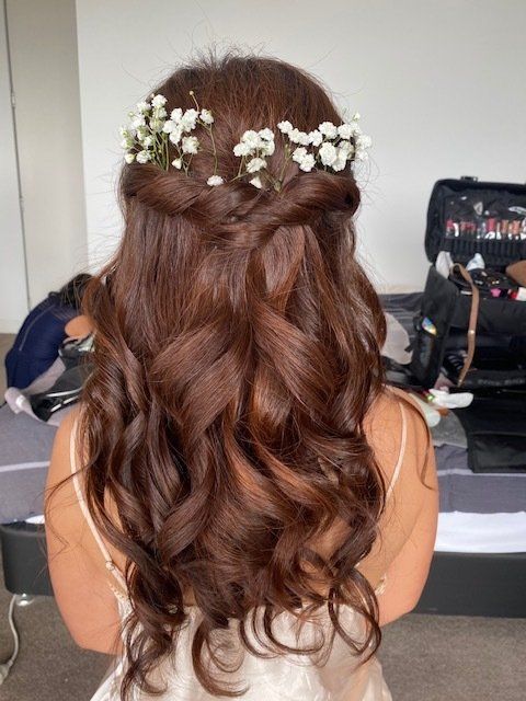 The back of a woman 's head with flowers in her hair.
