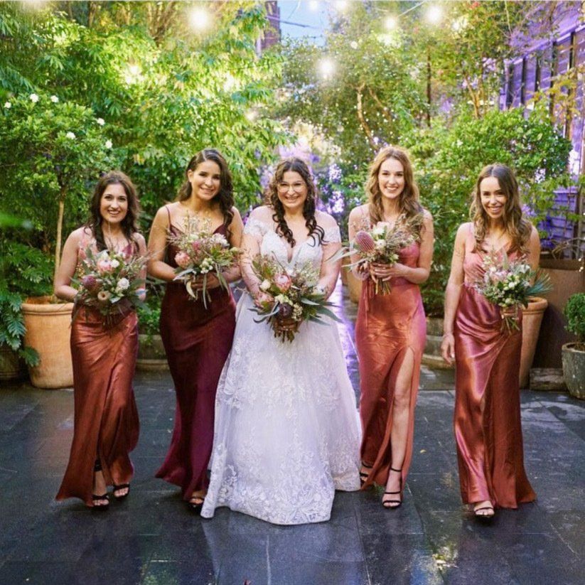 A bride and her bridesmaids are posing for a picture.