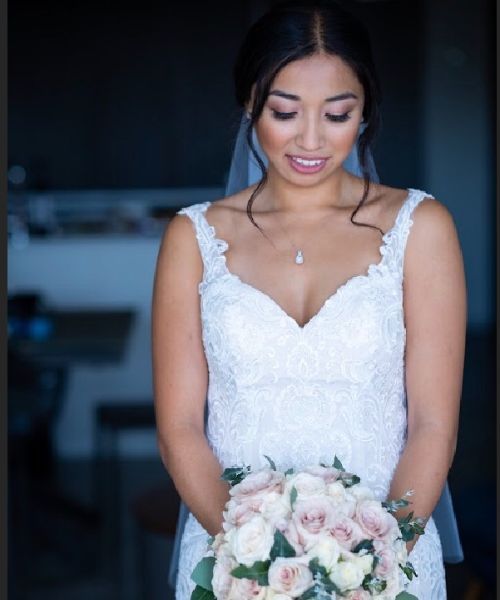 A woman in a wedding dress is holding a bouquet of flowers.