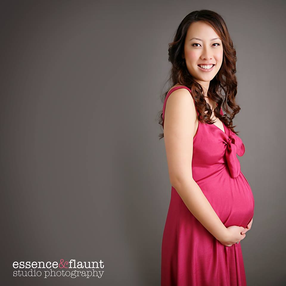 A pregnant woman in a pink dress is photographed by essence flaunt