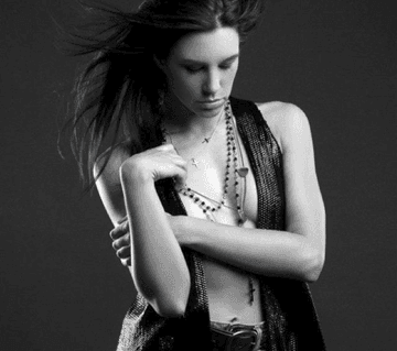 A black and white photo of a woman with her arms crossed