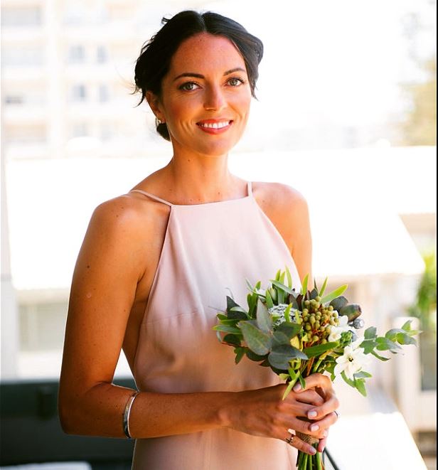 A woman in a pink dress is holding a bouquet of flowers