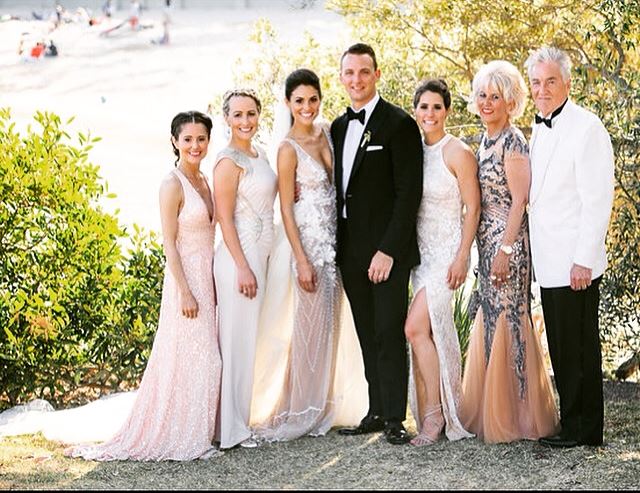 The bride and groom are posing for a picture with their family