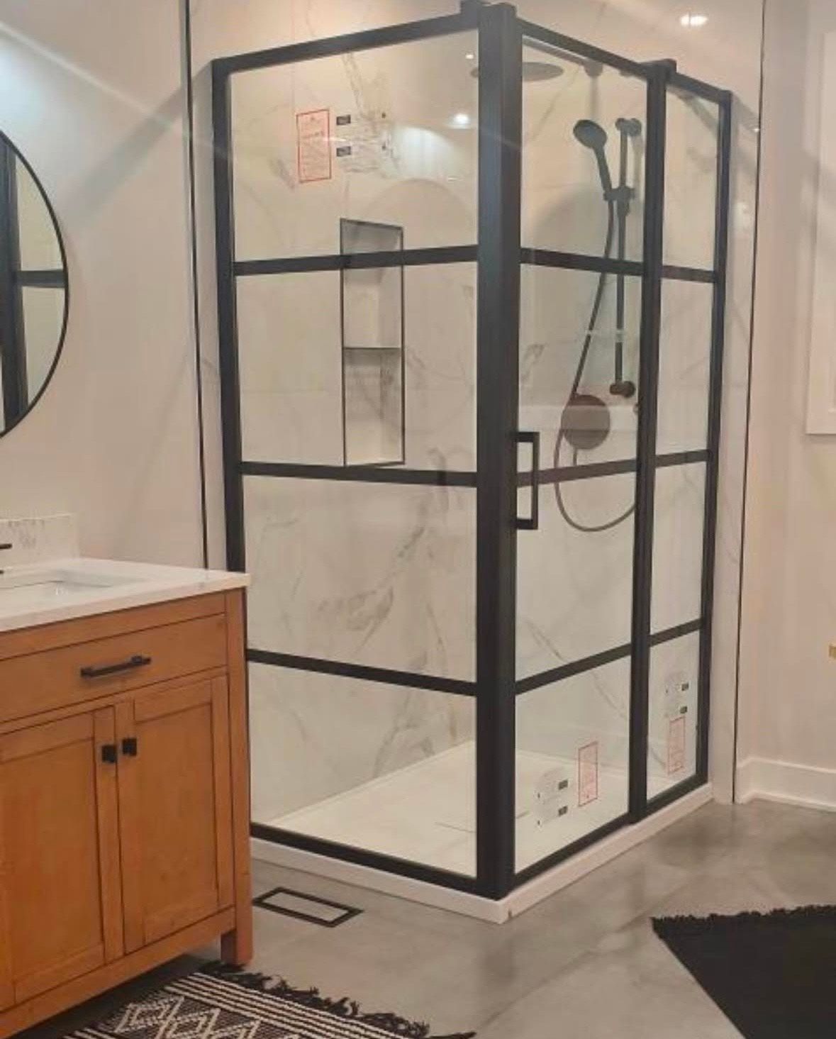 A bathroom with a walk in shower and a sink