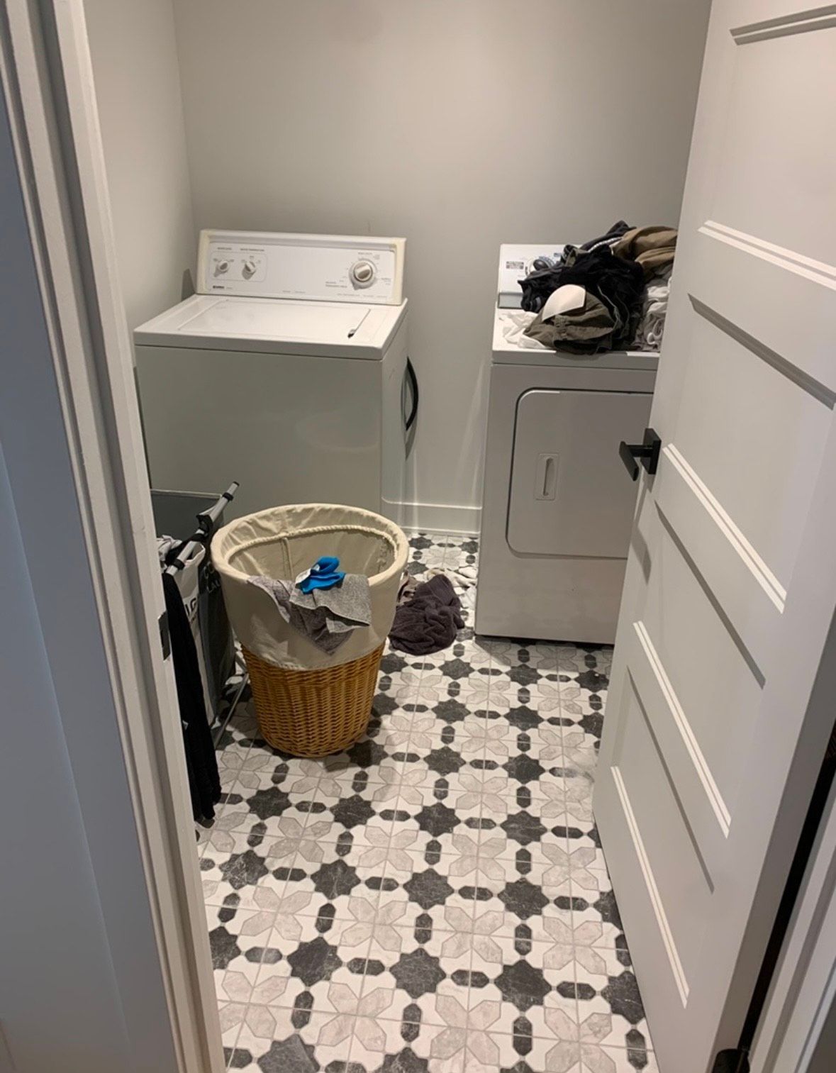 A laundry room with a washer and dryer and a basket.