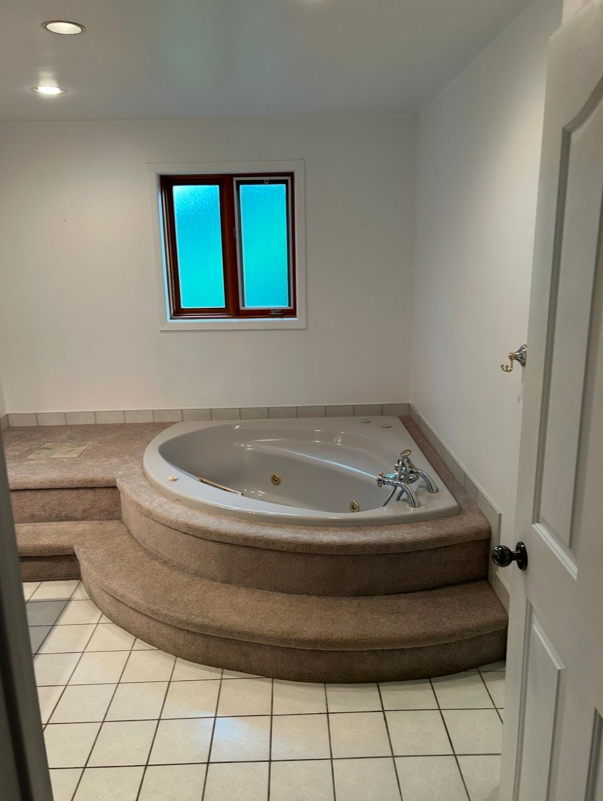 There is a large jacuzzi tub in the middle of the bathroom.