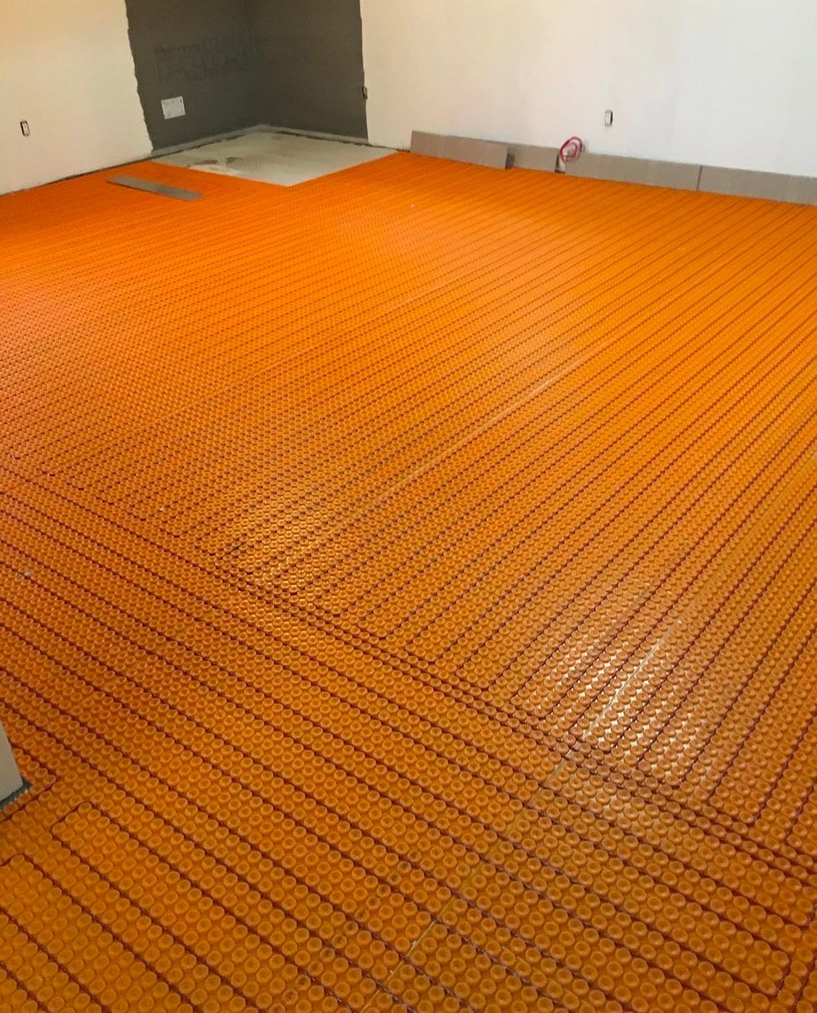 Une pièce avec un sol orange et un mur blanc.