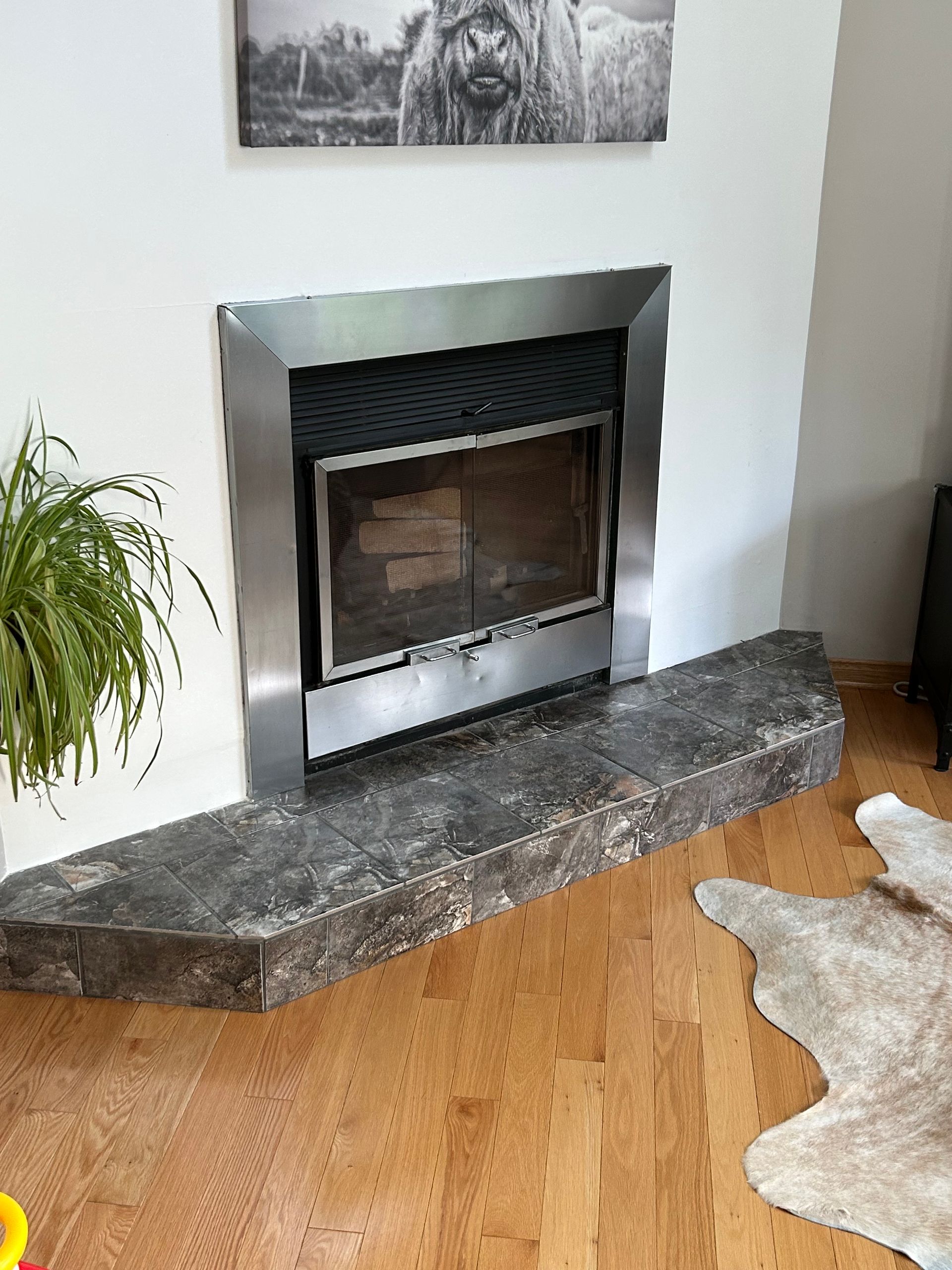 A fireplace in a living room with a picture on the wall above it.