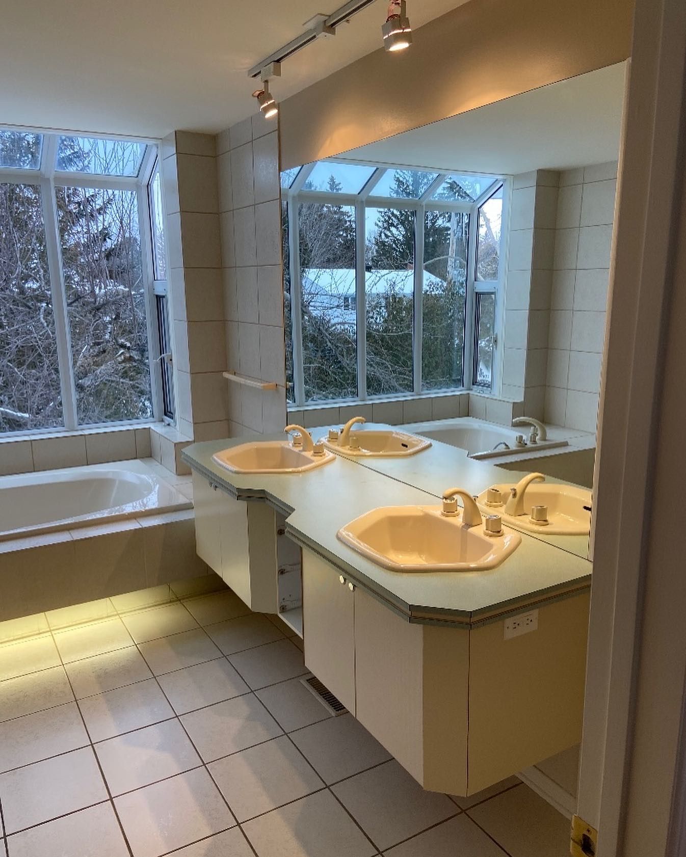 A bathroom with two sinks and a large mirror