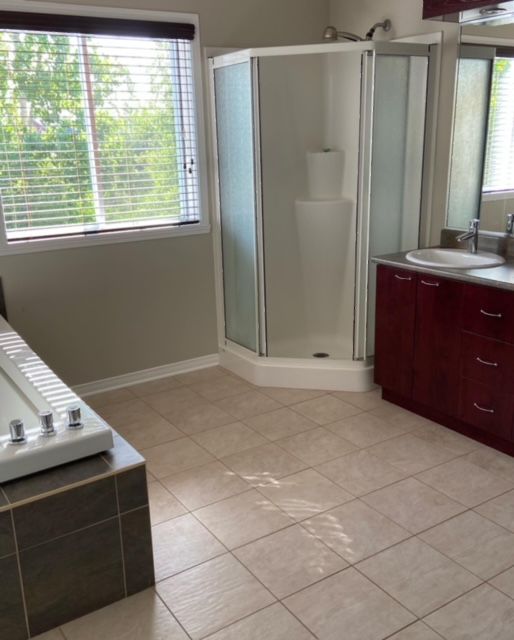 A bathroom with a tub a sink and a shower