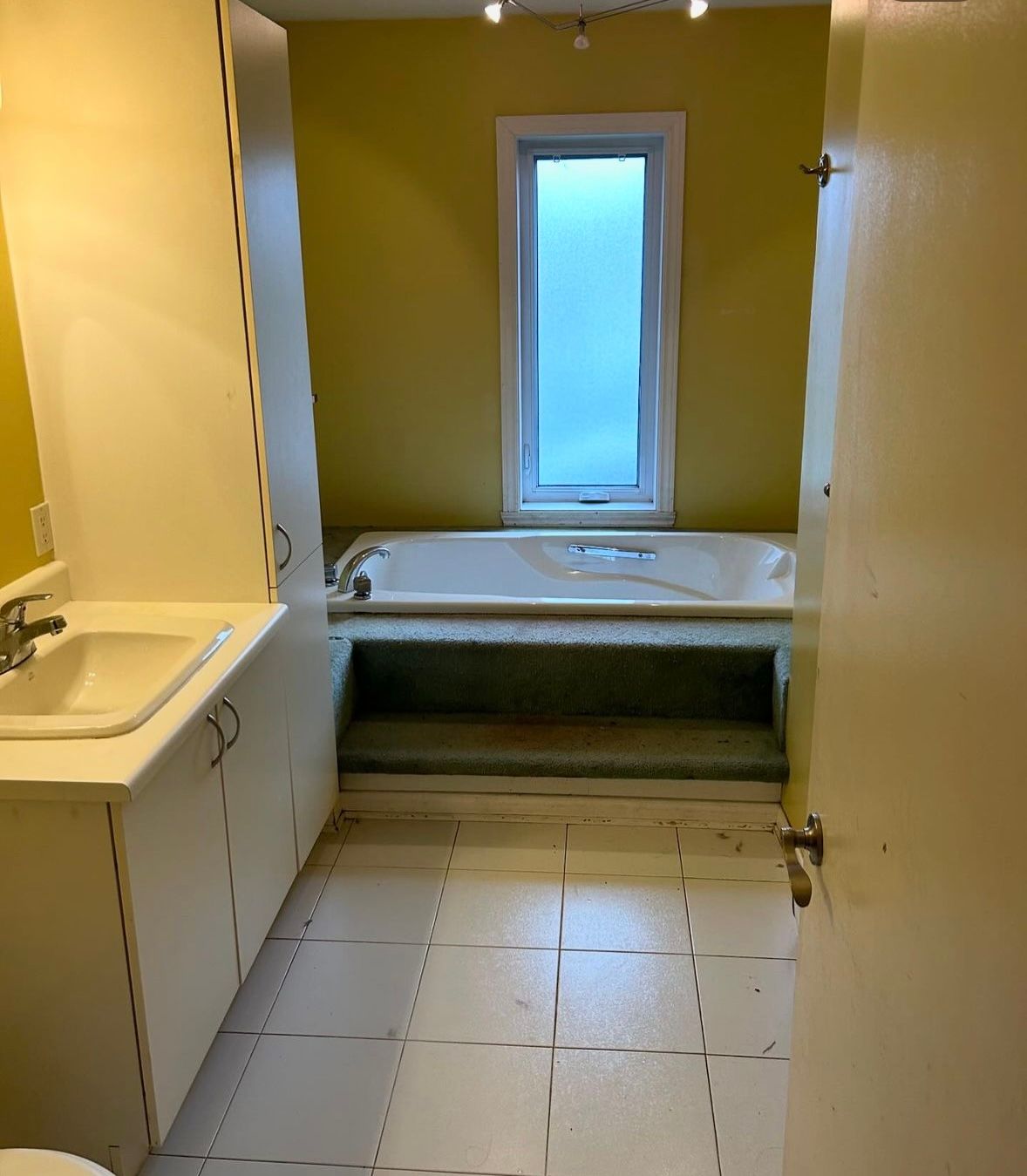 A bathroom with a tub a sink and a window