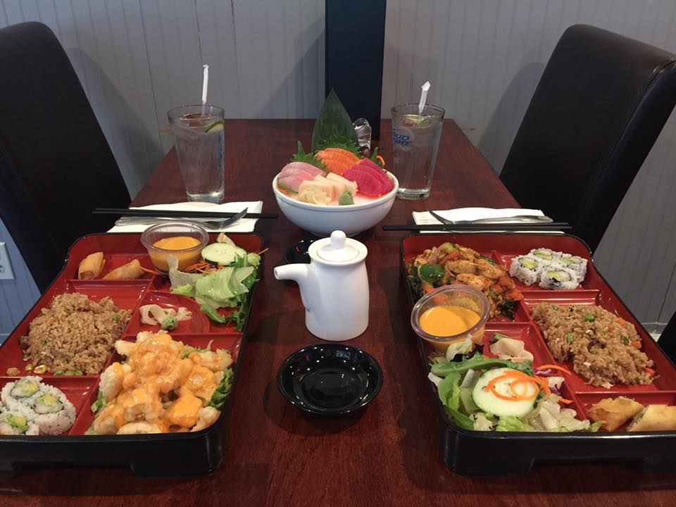 A table topped with plates of food and a bowl of fruit