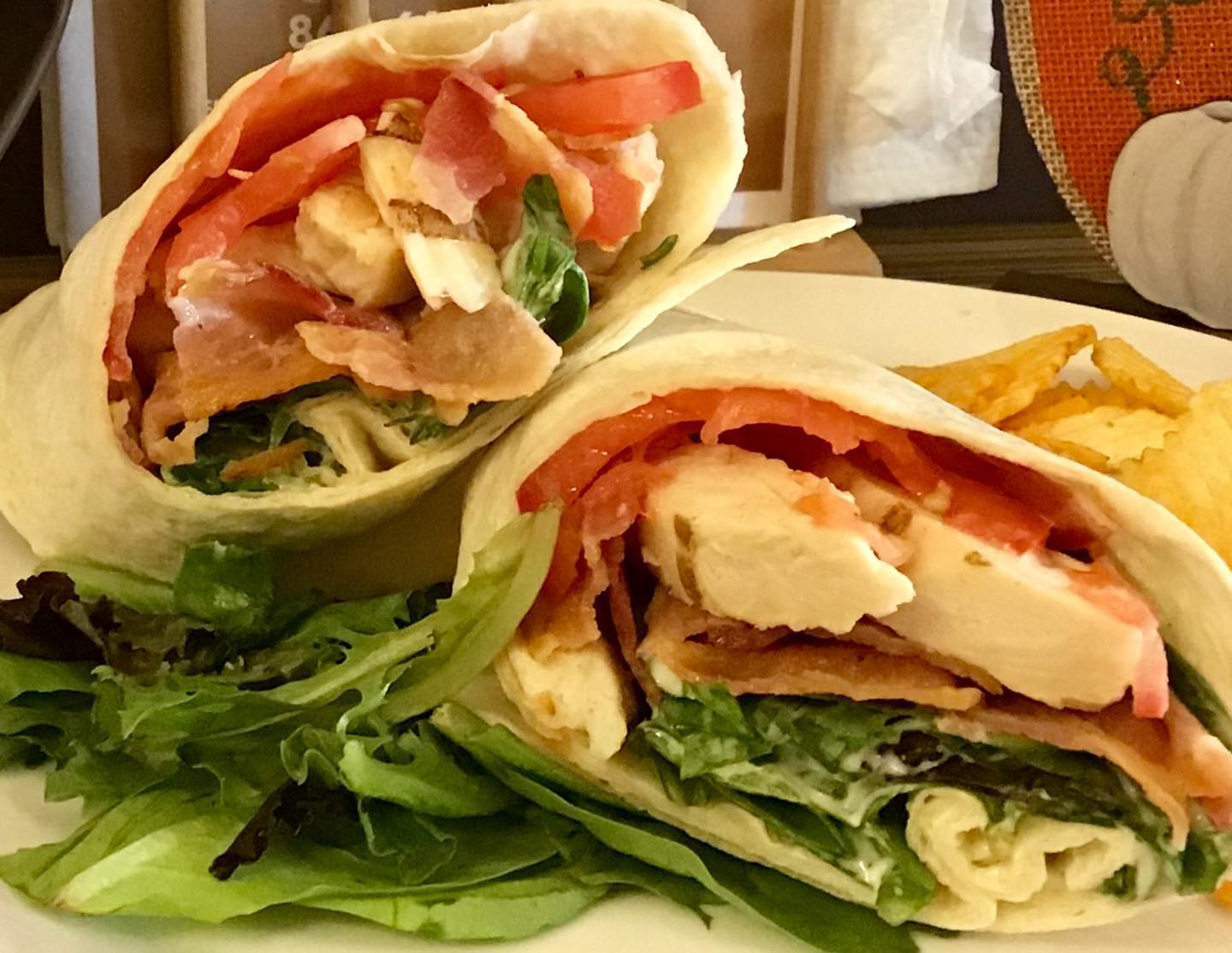 A close up of a sandwich on a plate with chips