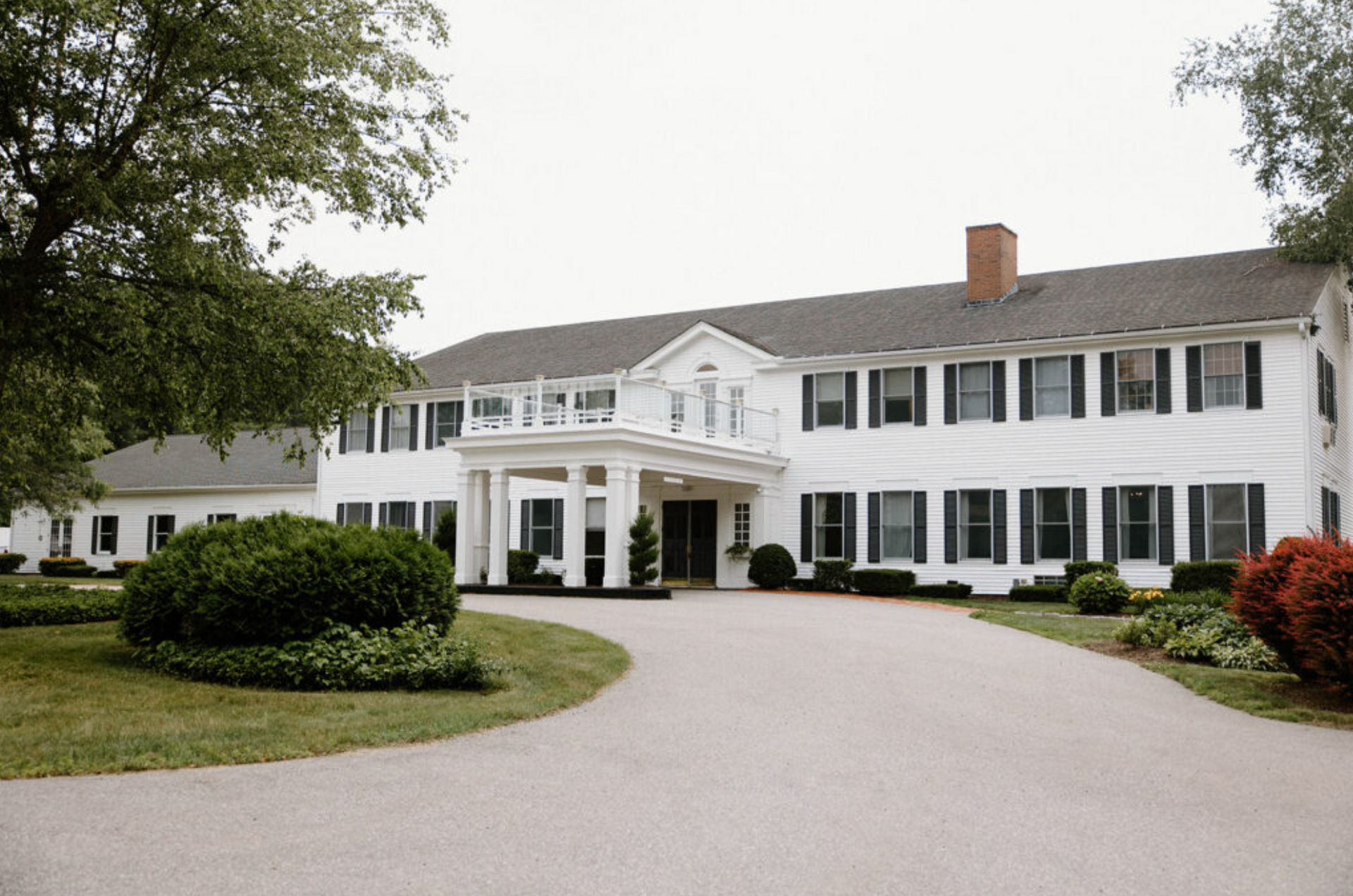 A large white house with a driveway leading to it