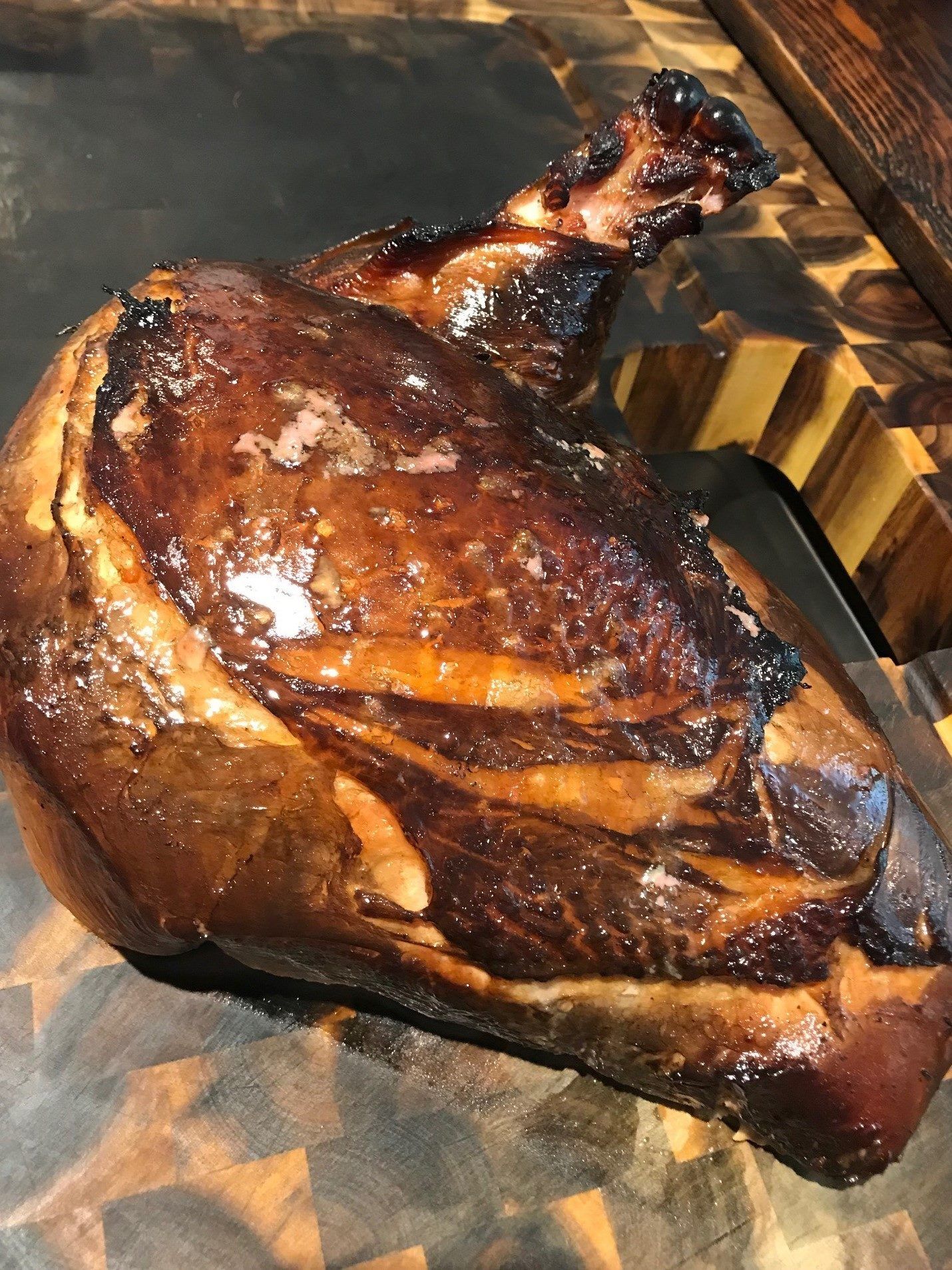 A large piece of meat is sitting on a wooden cutting board.