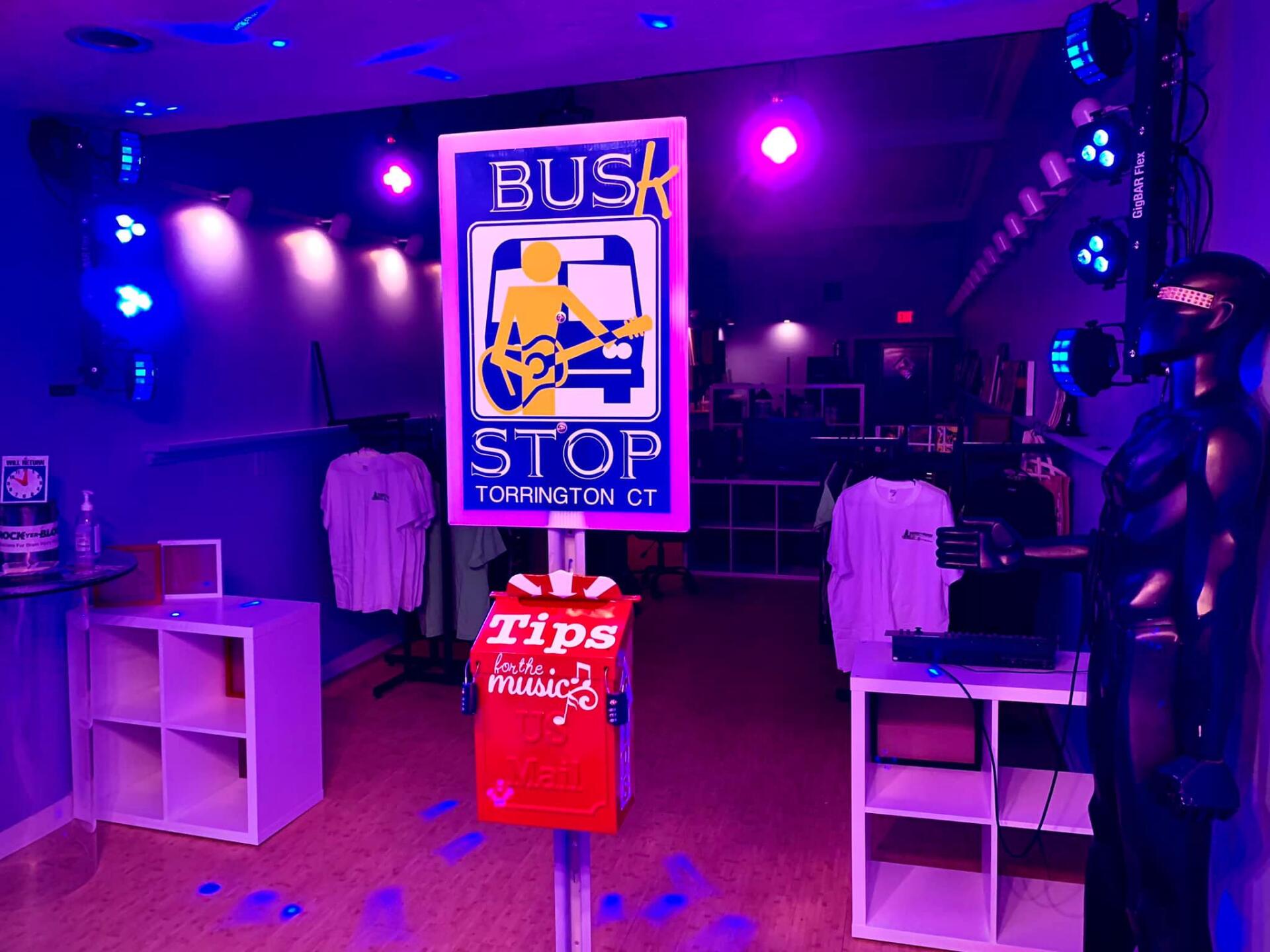 A bus stop sign in a store with purple lights