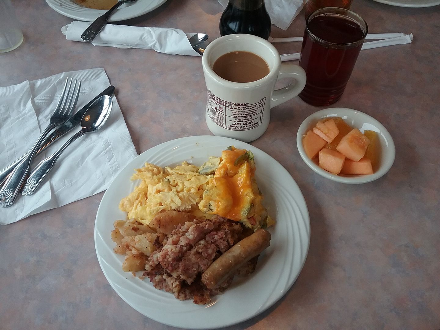 A plate of food with a cup of coffee on a table