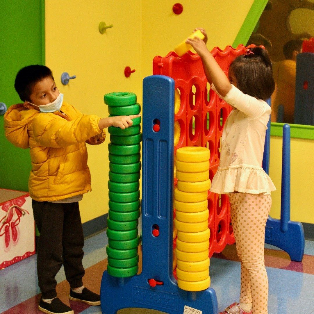 A boy and a girl are playing a game of connect four
