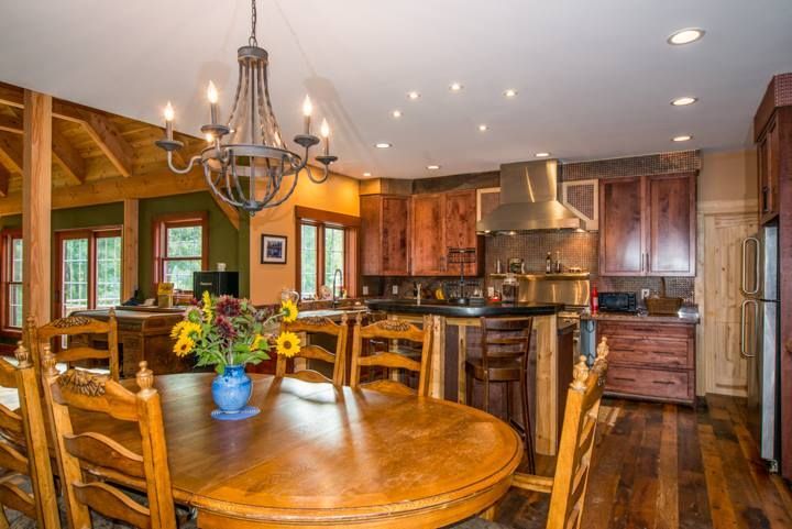 A kitchen with a table and chairs and a chandelier hanging from the ceiling.
