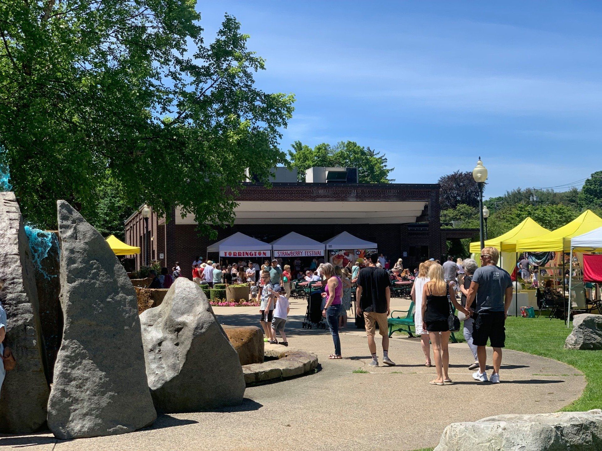 A group of people are walking down a path in a park.