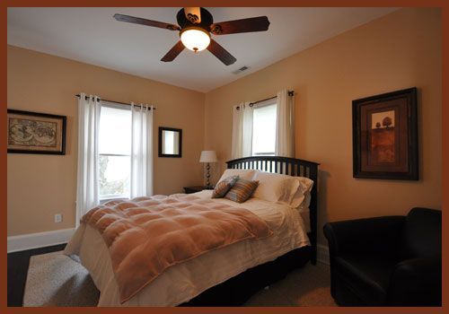 A bedroom with a bed and a ceiling fan