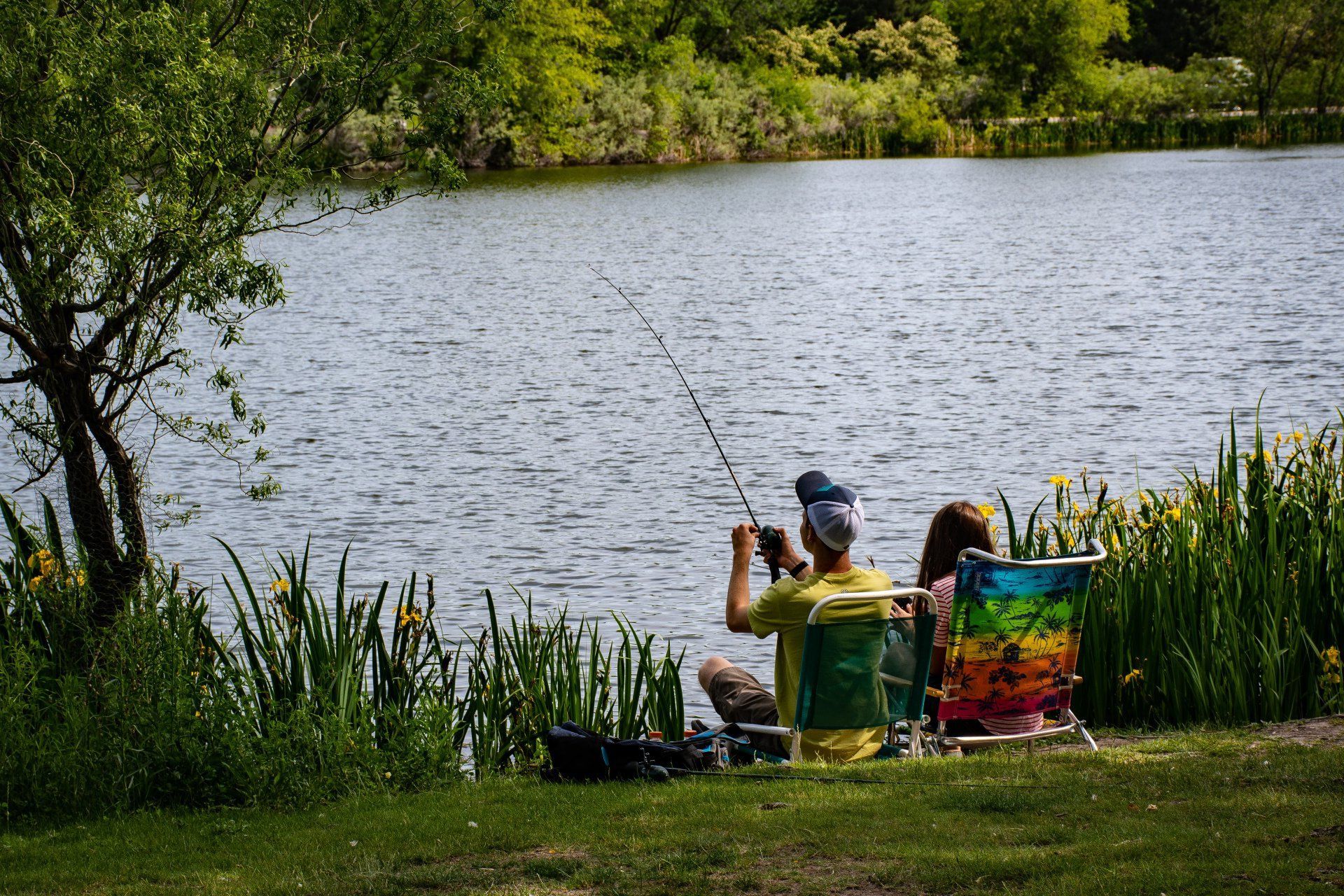 A man and a woman are fishing in a lake.