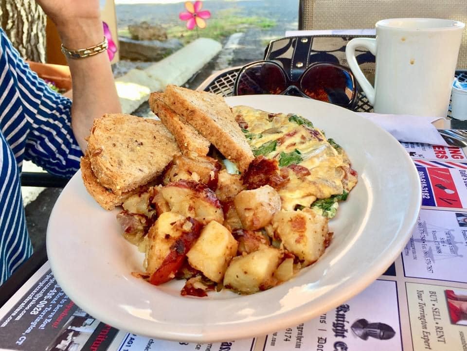 A plate of food with a sandwich and potatoes on a table