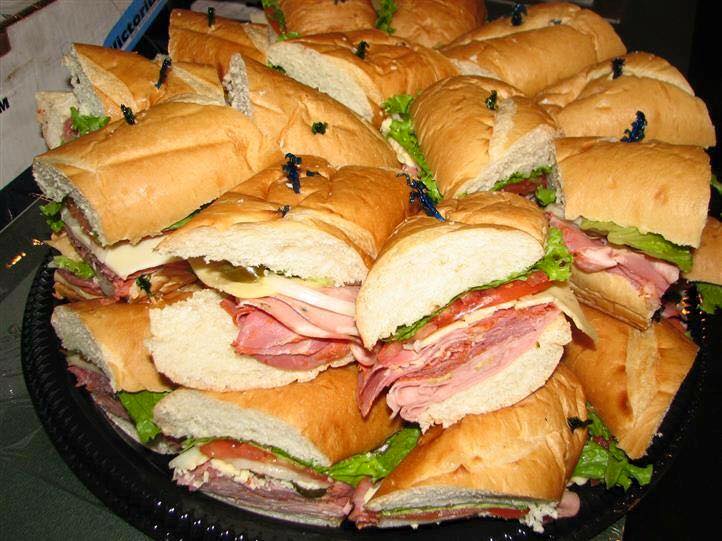A bunch of sub sandwiches on a black plate