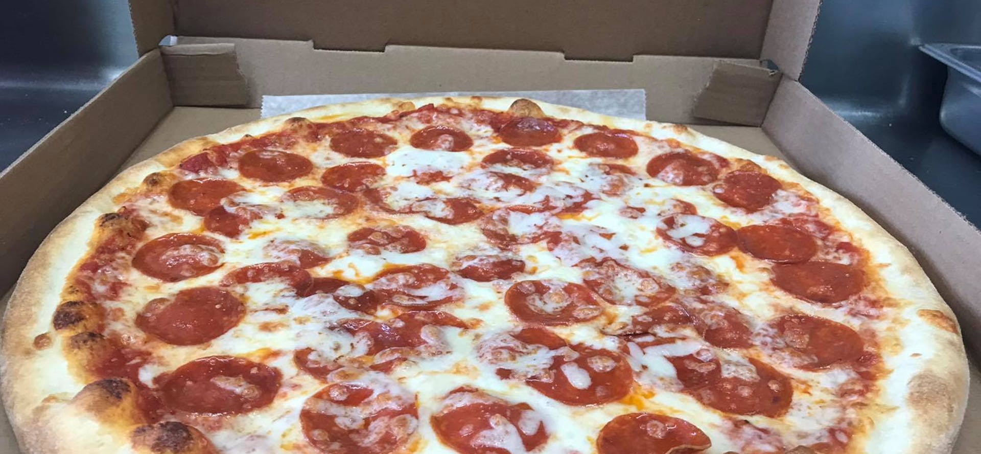 A pepperoni pizza is sitting in a cardboard box.