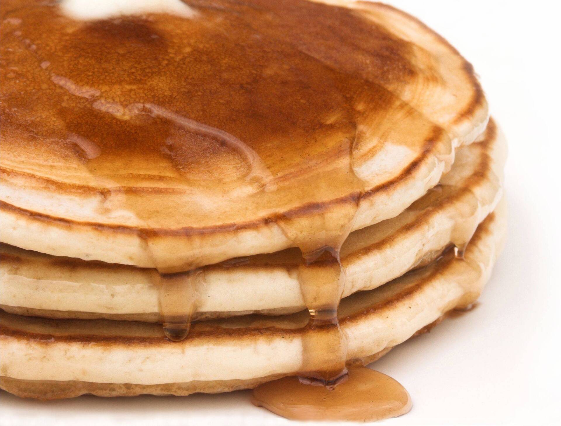 A stack of pancakes with syrup and butter on top