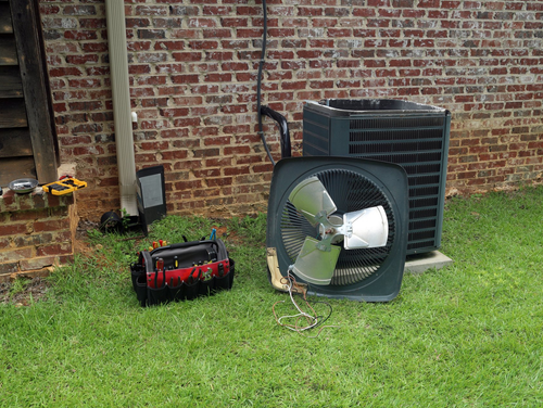 Heating — Man Checking Air Conditioner At Home in Shoals, AL