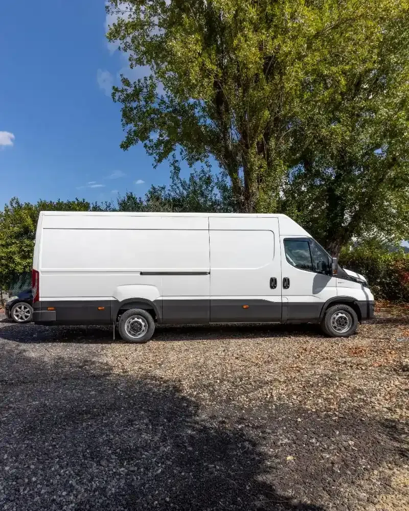 Vista posteriore di un camion industriale bianco con un grande serbatoio cilindrico, in un garage.