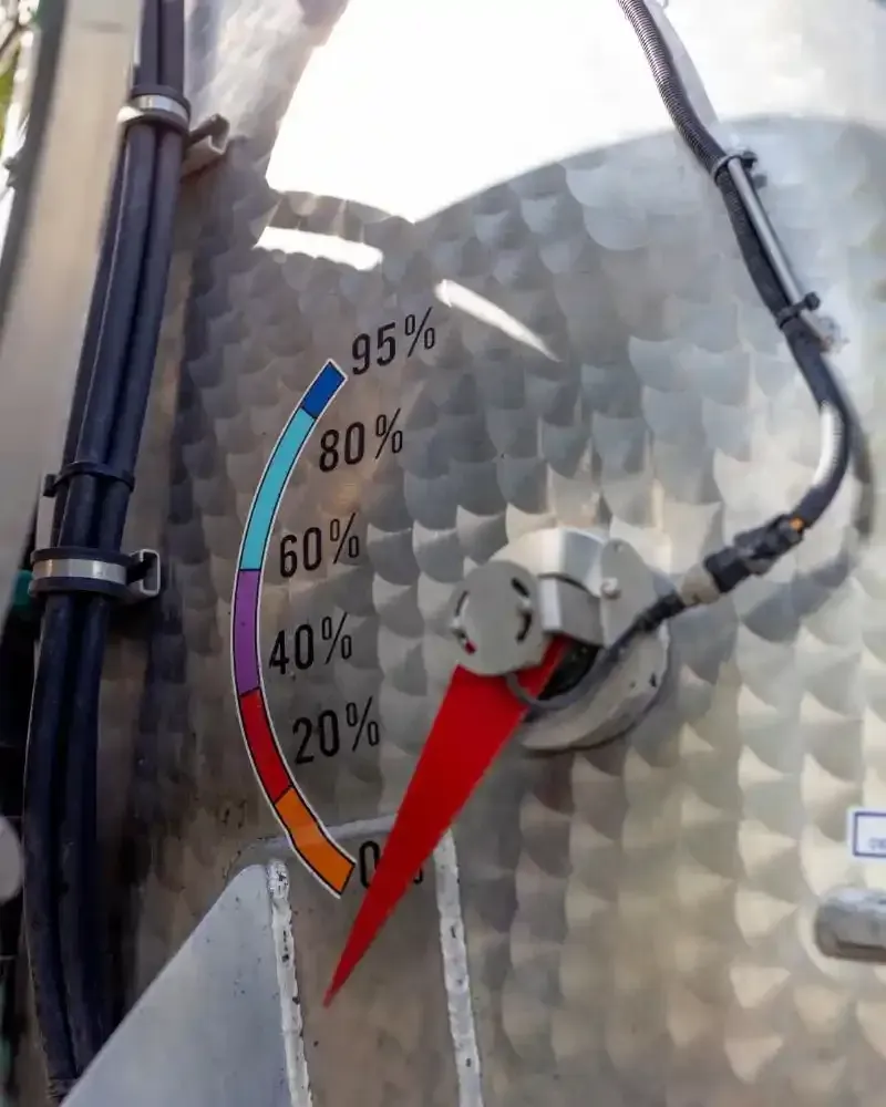 Un camion aspiratutto blu e bianco parcheggiato fuori da un edificio.