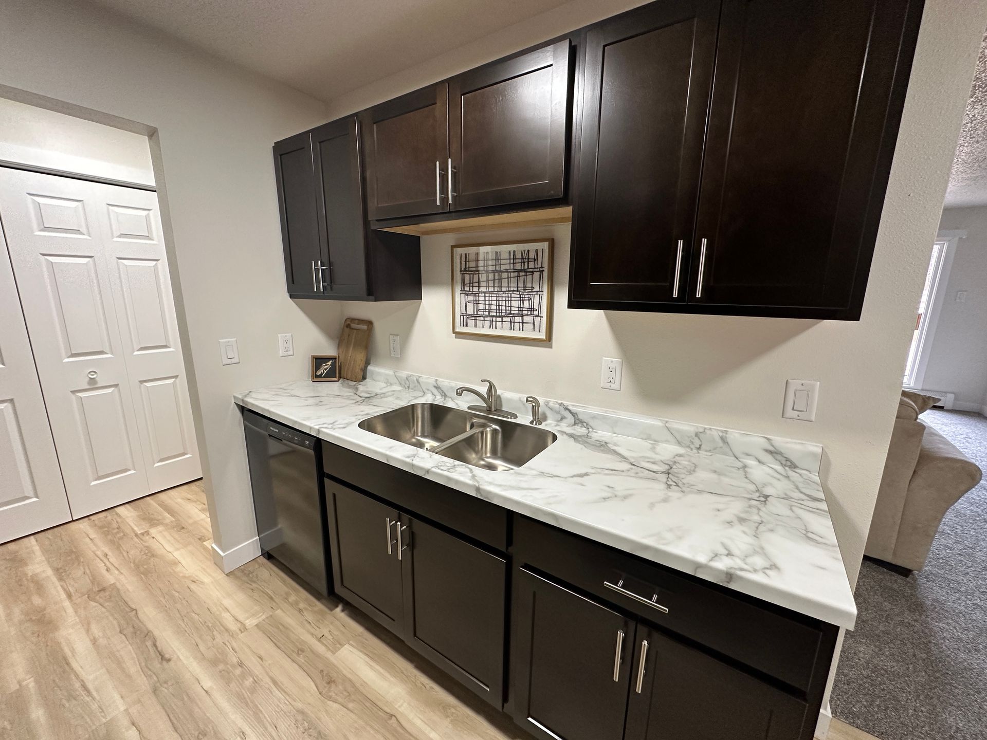 A kitchen with two sinks and a marble counter top.