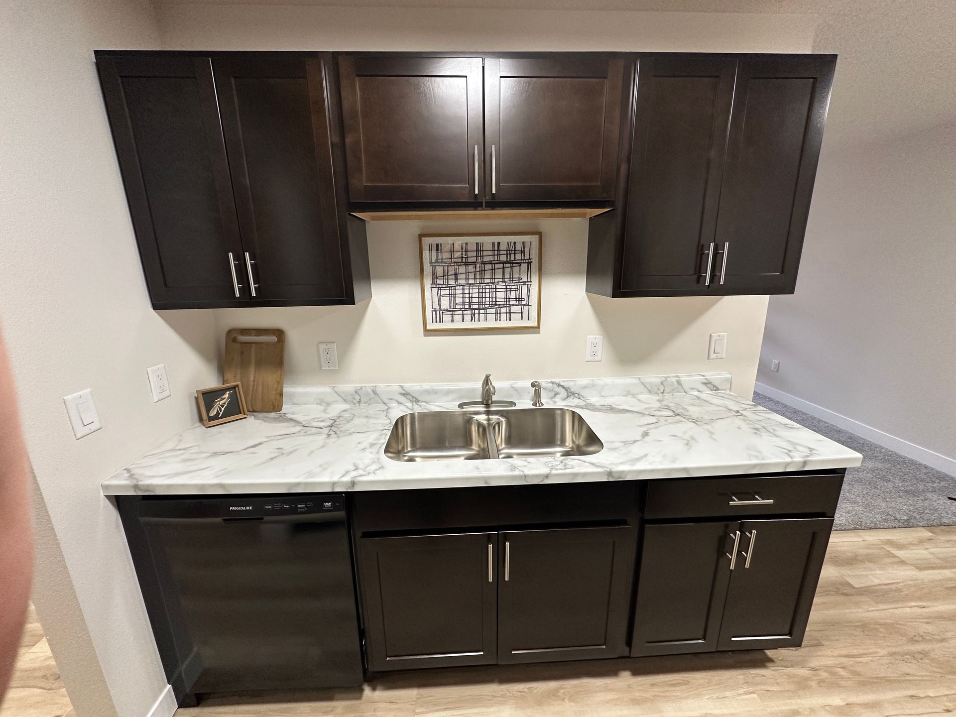 A kitchen with a sink , cabinets and a dishwasher