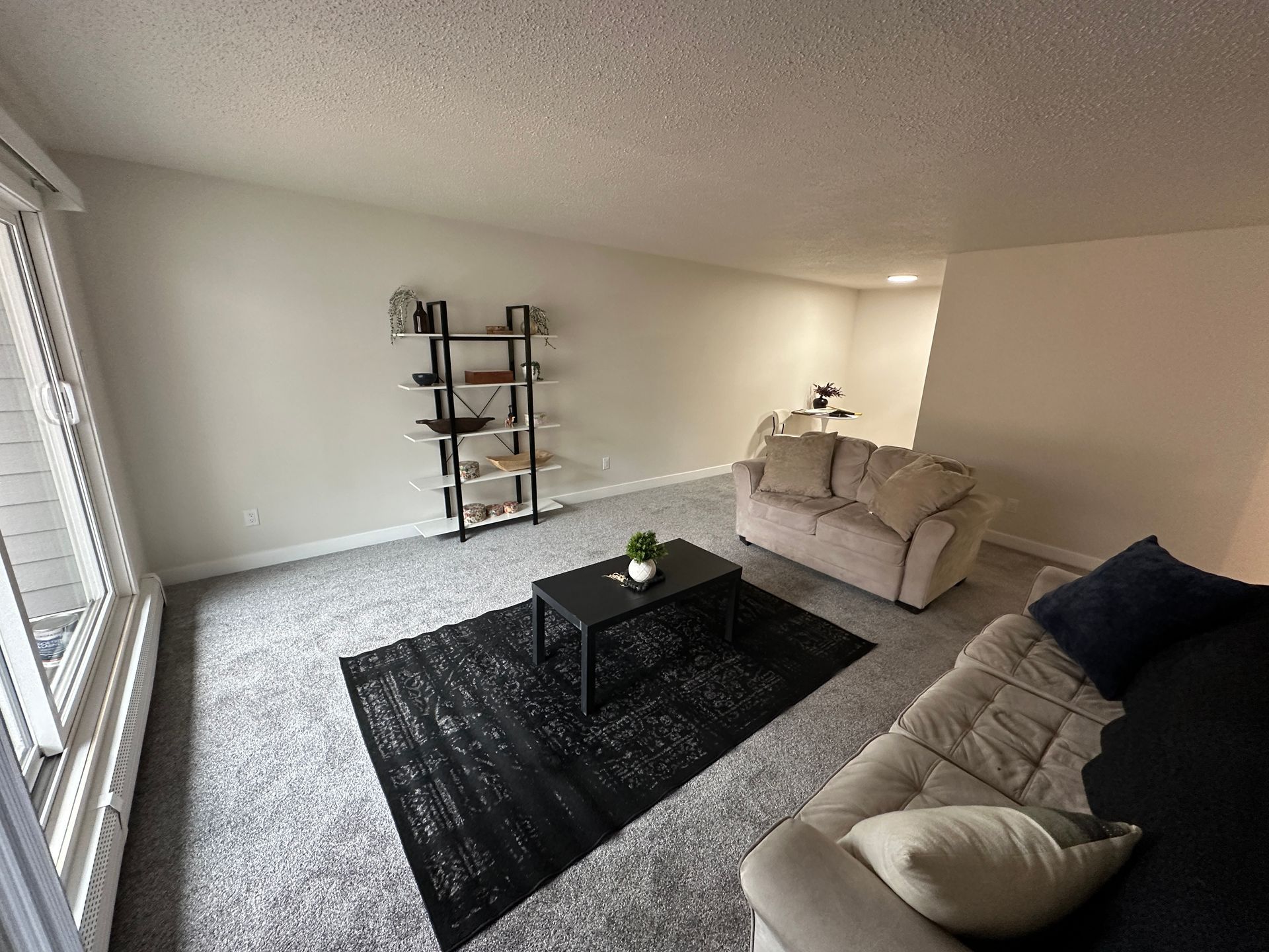 A living room with a couch , coffee table and rug.
