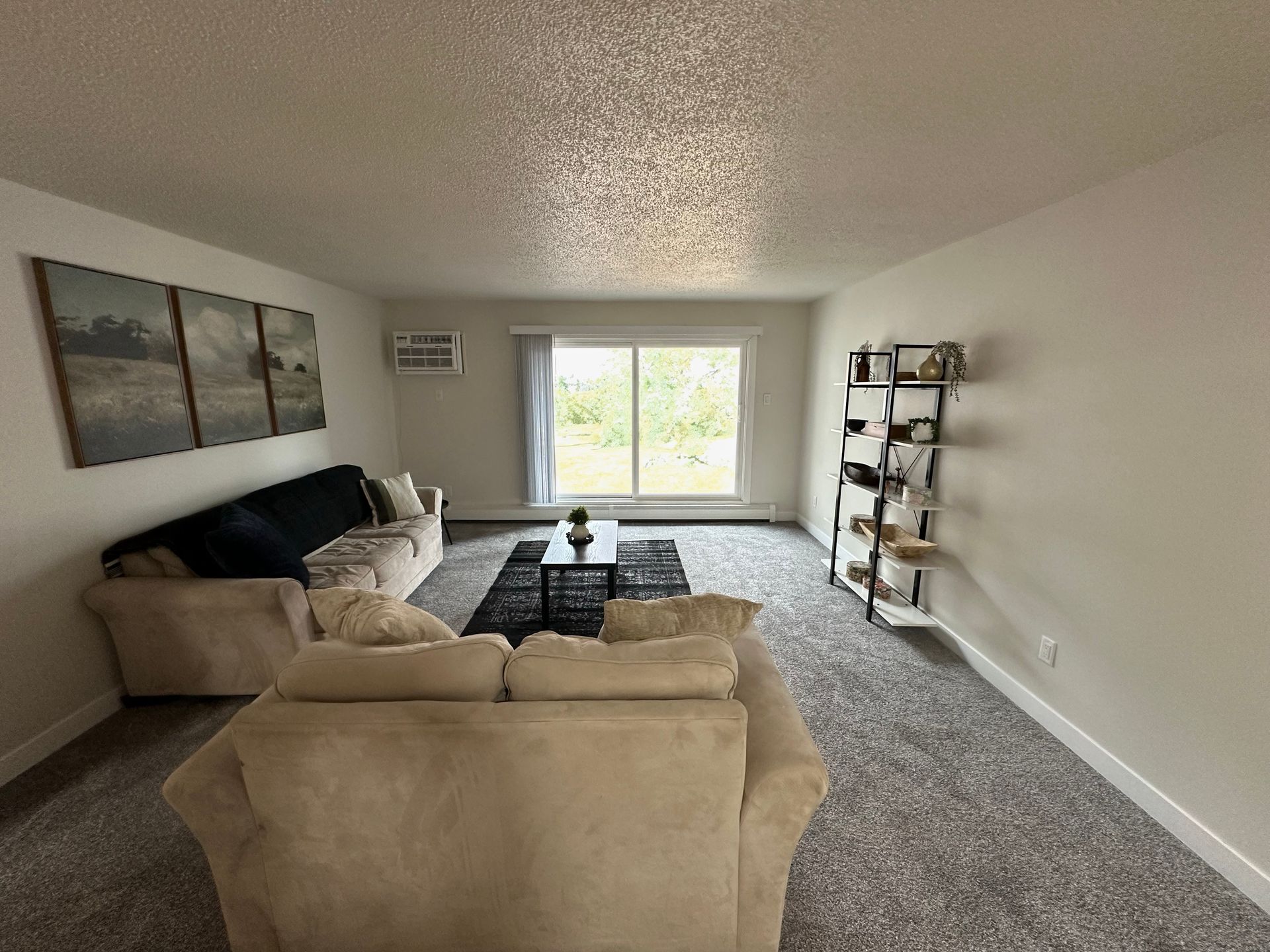 A living room filled with furniture and a sliding glass door.