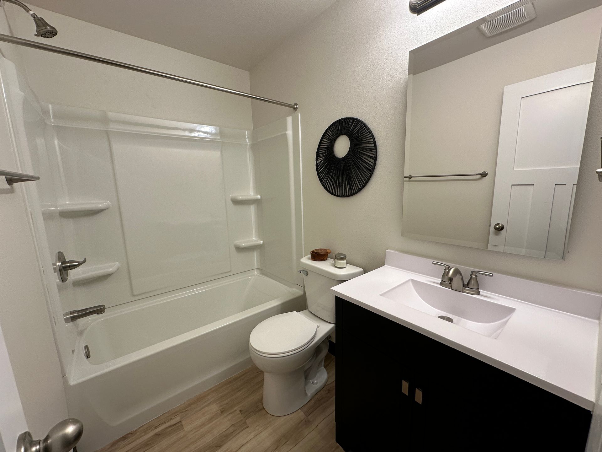 A bathroom with a toilet , sink and bathtub.