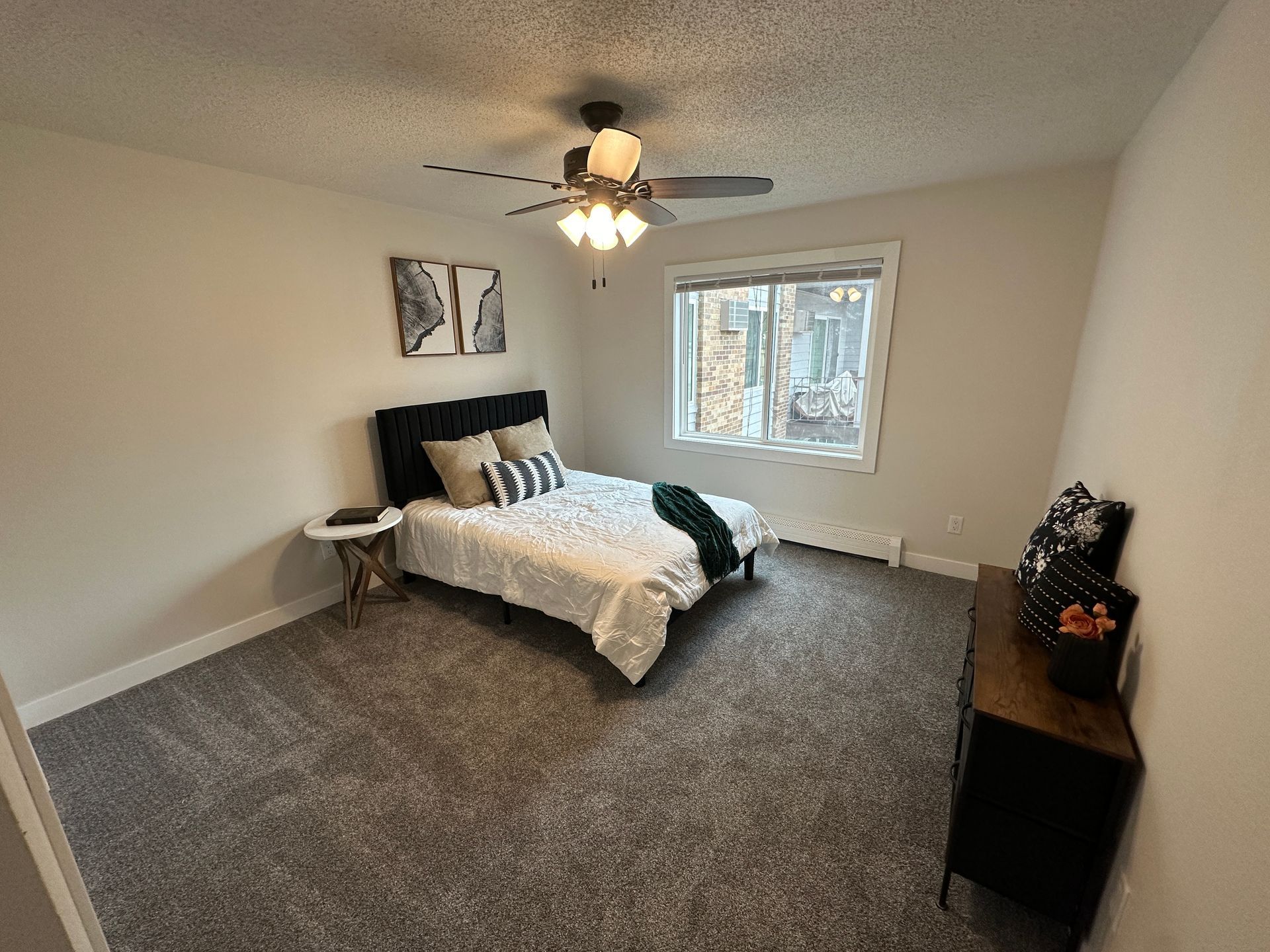 A bedroom with a bed and a ceiling fan.