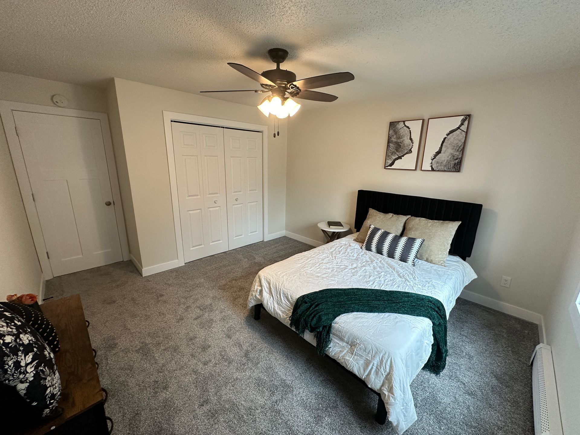 A bedroom with a bed and a ceiling fan.